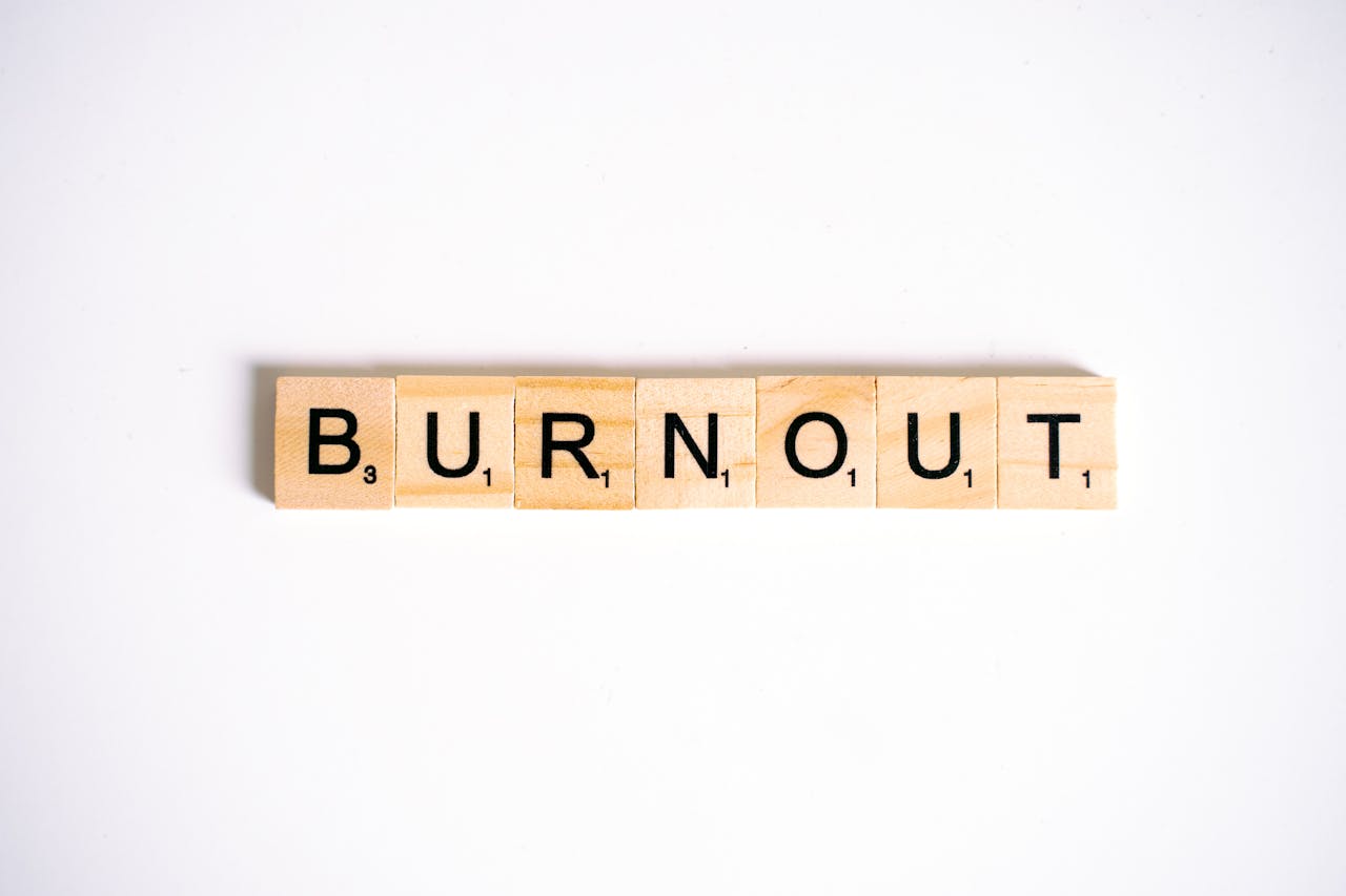 Conceptual image of Burnout spelled with Scrabble tiles on a white background.